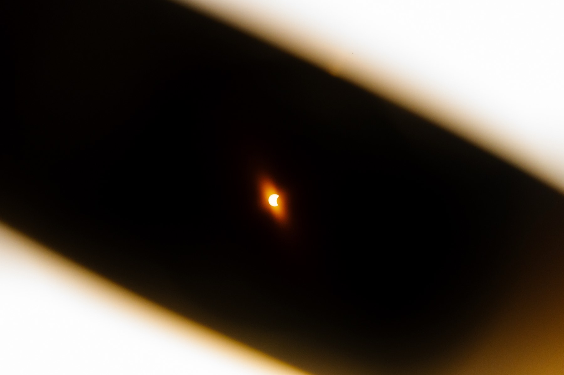 Crescent sun of the partial solar eclipse seen through eclipse glasses from a boat near Cascais, Portugal