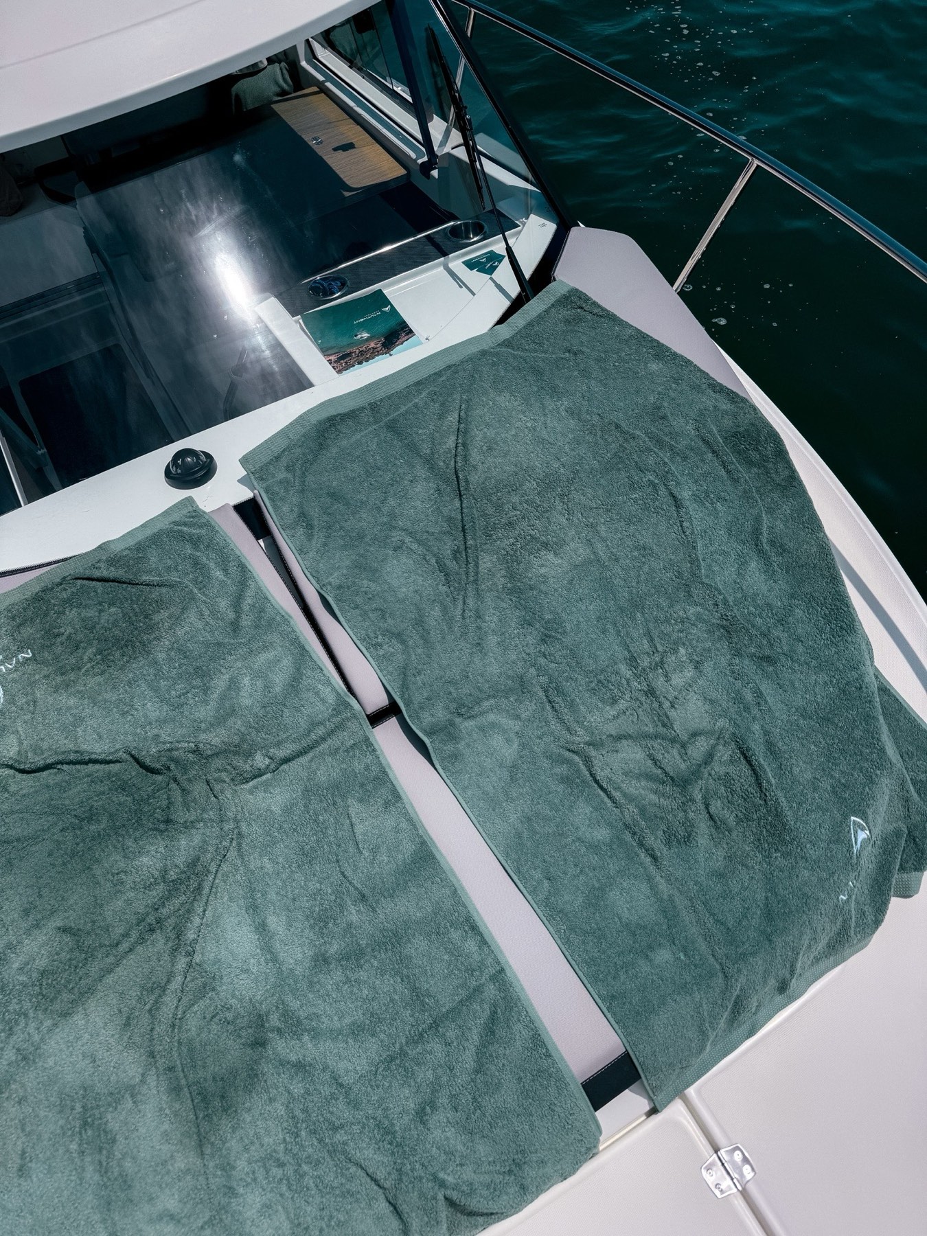 Nautivent towels laid out on the sunpads of a private charter boat in Cascais