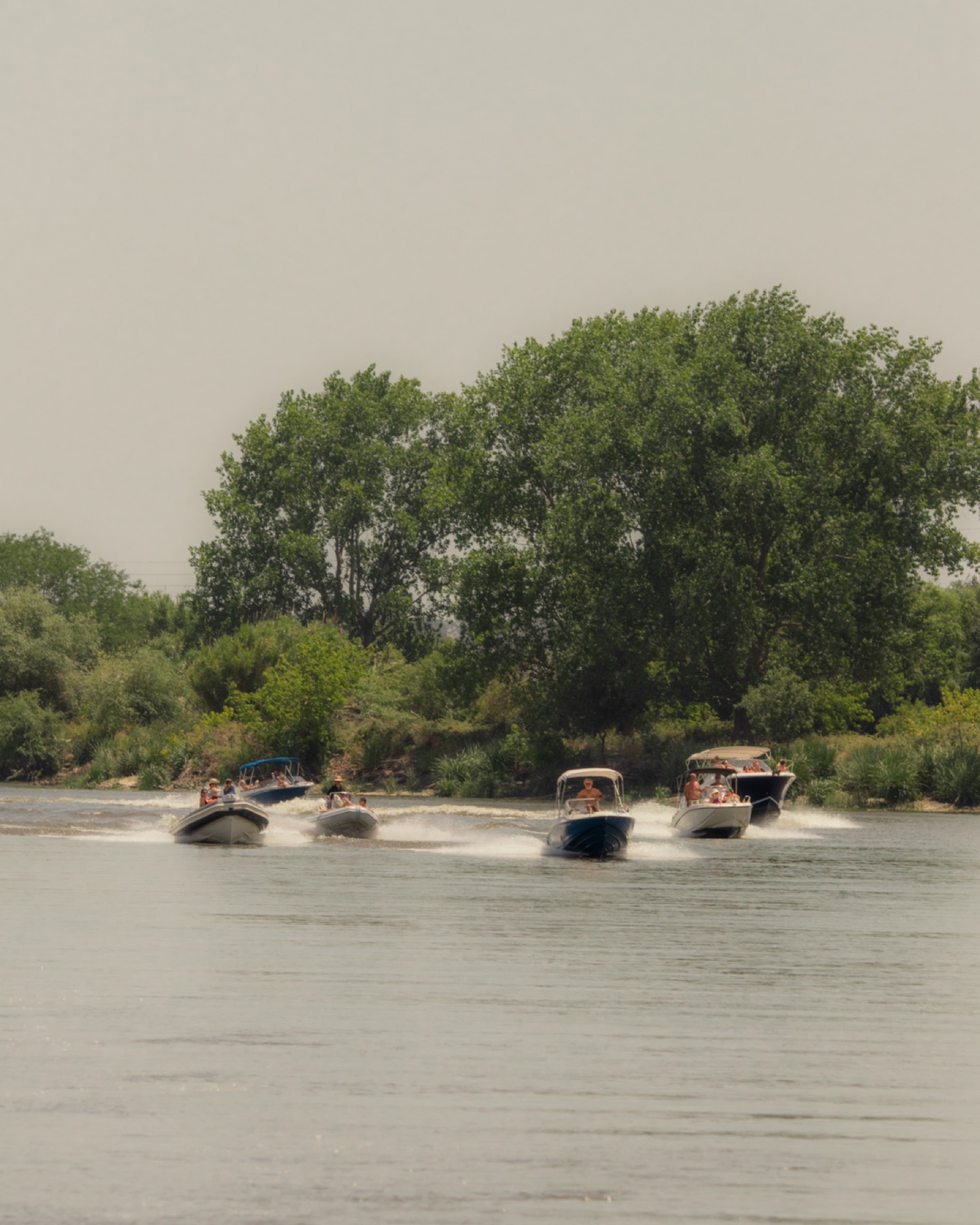Boats cruising the calm green waters of the Tejo river near Valada, Portugal