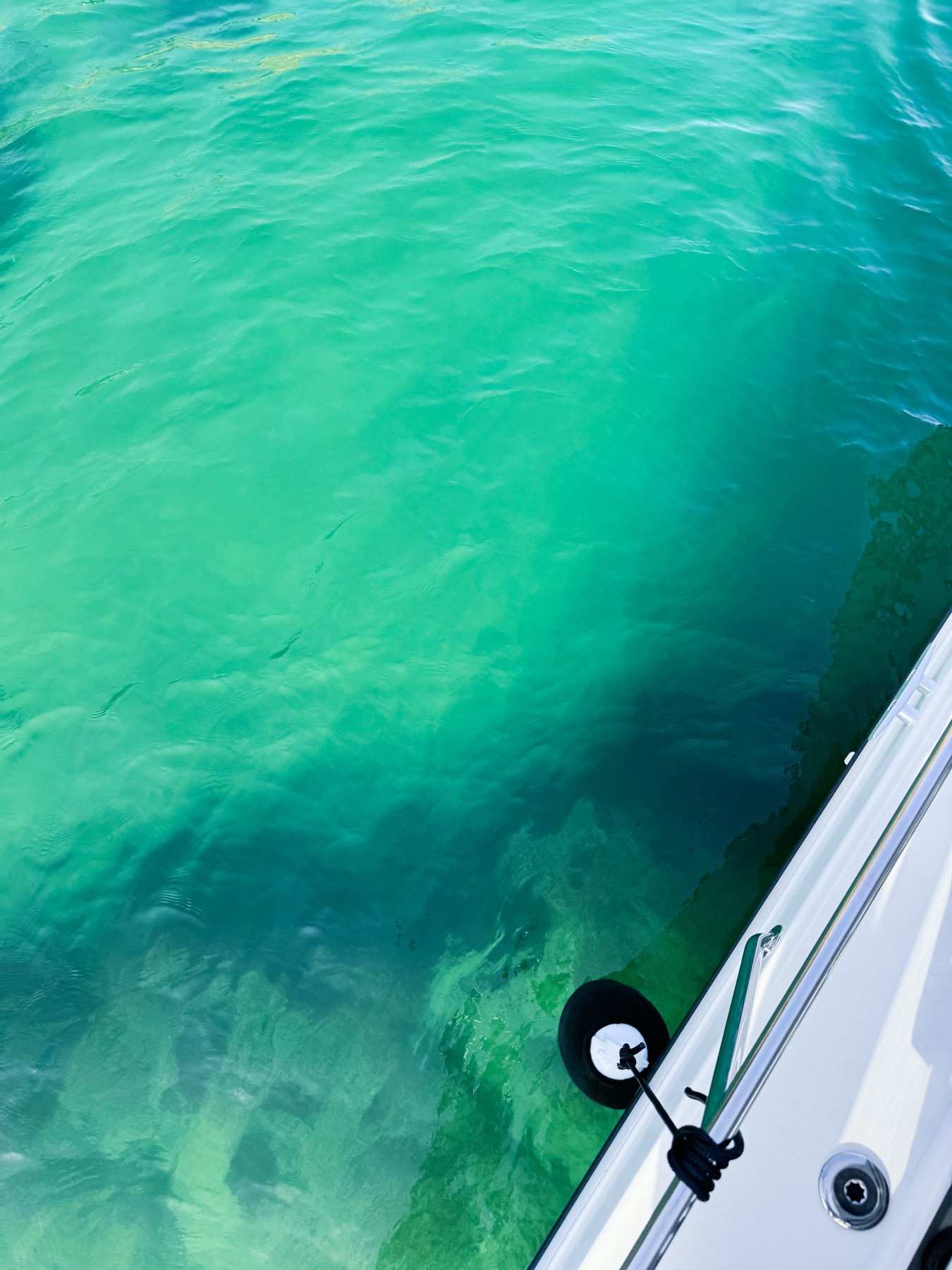 Turquoise swimming spot beside a private boat on the Cascais coast